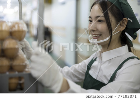 A female employee working with a mouse shield in the backyard of a supermarket 77192871