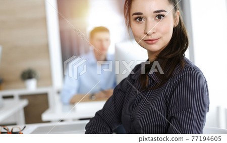 Business woman using computer at workplace in sunny office. Working for pleasure and success Business woman using computer at workplace in sunny office. Working for pleasure and success 77194605