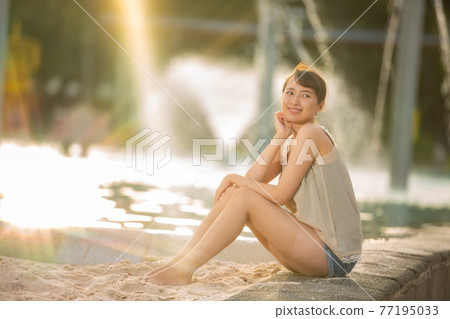 她坐在燈光下的潟湖池前 77195033