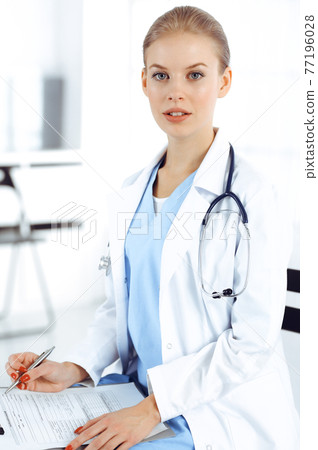 Woman - doctor consults her female patient while using clipboard and medication history record. Medicine concept Woman - doctor consults her female patient while using clipboard and medication history record. Medicine concept 77196028