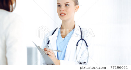 Woman - doctor consults her female patient while using clipboard and medication history record. Medicine concept Woman - doctor consults her female patient while using clipboard and medication history record. Medicine concept 77196031
