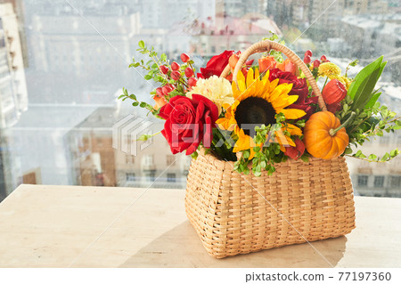 Mixed autumn flowers in basket, bouquet is on the windowsill with copy space. Mixed autumn flowers in basket, bouquet is on the windowsill with copy space. 77197360