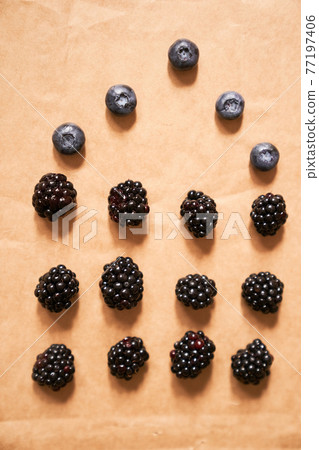 Five blueberries and twelve blackberries on a beige background, form of a house Five blueberries and twelve blackberries on a beige background, form of a house 77197406