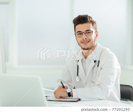 doctor therapist sitting at a table in his office doctor therapist sitting at a table in his office 77201293