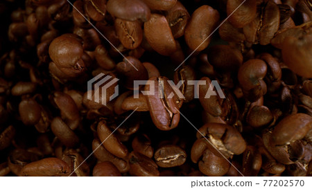 Roasted coffee beans flying up in the air Roasted coffee beans flying up in the air 77202570
