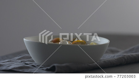 put kumato tomatoes on fettuccine in white bowl on linen cloth put kumato tomatoes on fettuccine in white bowl on linen cloth 77203003