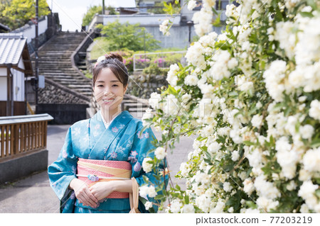 A young woman in a kimono taking a commemorative photo with the slope of Ameya in the background [Kitsuki City] 77203219
