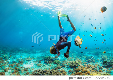 Young man in snorkelling mask dive underwater 77203250
