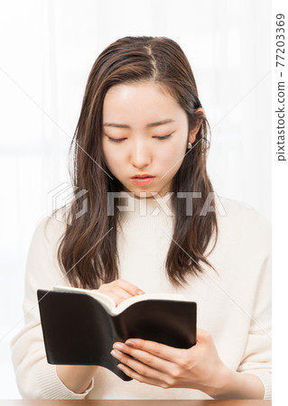 A woman taking a note 77203369