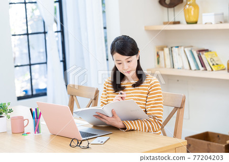 A lady with a computer in the living room 77204203