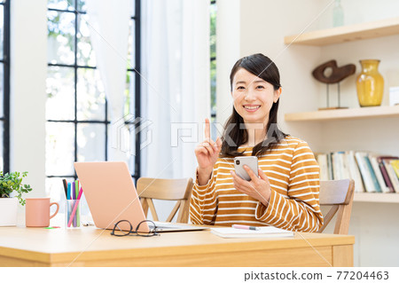 A lady with a computer in the living room 77204463