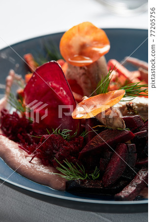 Beet summer salad with arugula, radicchio, soft cheese and walnuts on plate dressing and spices on blue plate, copy space, top view Beet summer salad with arugula, radicchio, soft cheese and walnuts on plate dressing and spices on blue plate, copy space, top view 77205756