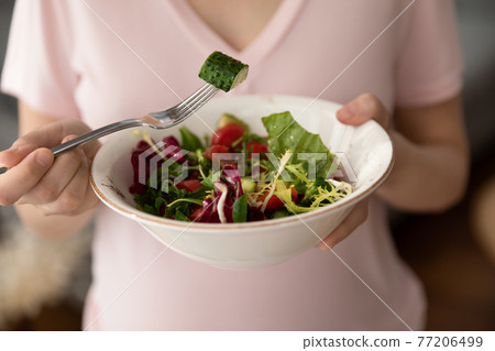 Close up of pregnant woman eat green salad 77206499