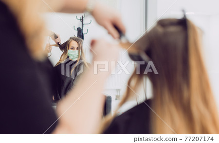 Hair stylist and customer during coronavirus pandemic wearing mask Hair stylist and customer during coronavirus pandemic wearing mask 77207174