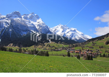 Village Gsteig bei Gstaad and snow covered mountains. 77208007