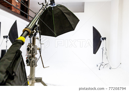 Empty photo studio with lighting equipment. Photographer workplace interior with professional tool set gear. Flash light white background scenes ready for studio shooting. Modern photographer studio Empty photo studio with lighting equipment. Photographer workplace interior with professional tool set gear. Flash light white background scenes ready for studio shooting. Modern photographer studio 77208794