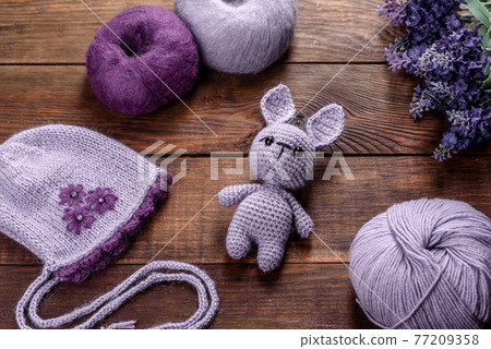 Toy hare tied from woolen threads on a dark background Toy hare tied from woolen threads on a dark background 77209358