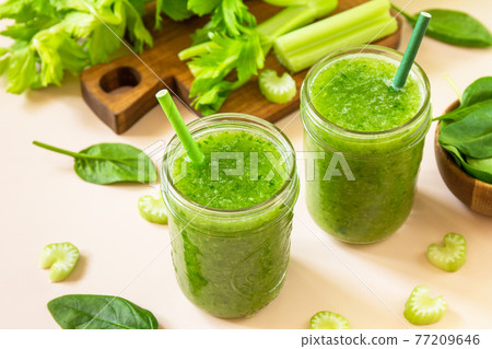 Vegan smoothie recipe. Healthy diet and nutrition, vegan and alkaline drink. Green fresh smoothie with celery and spinach on a pink background. 77209646
