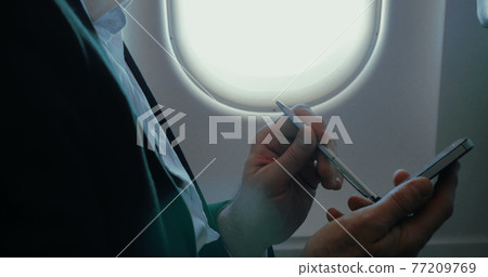 Businessman using smart phone during the flight 77209769