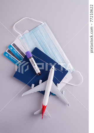 Trendy travel accessories, documents, dollars, passports, boarding tickets, sanitizer, and protective face mask. Traveling during coronavirus pandemic 77210622