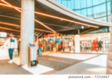 People shop window blurred background. Interior of retail centre store in soft focus. People shopping in modern commercial mall center. Sale, consumerism and people concept. 77210847