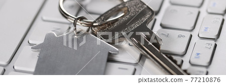 On keyboard are keys with the house keychain 77210876
