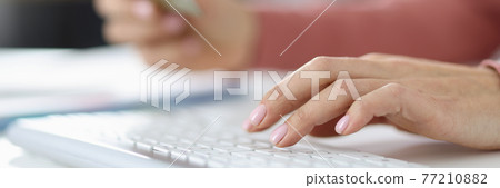 Female hand on keyboard in the second hand holding credit bank card 77210882