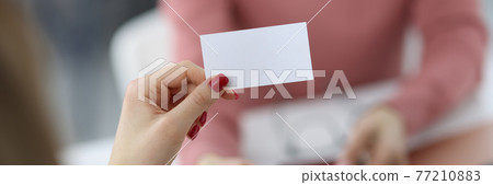 Female hands are holding white business card Female hands are holding white business card 77210883