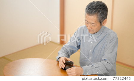 Senior man drinking tea in a Japanese-style room 77212445