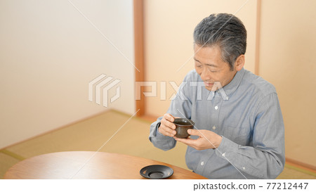 Senior man drinking tea in a Japanese-style room 77212447