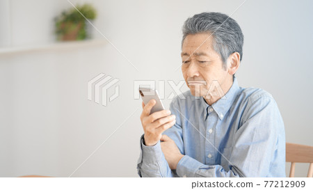 努力操作智能手機的老人 77212909