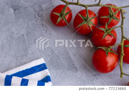 Cherry tomatoes on blue brushstroke background Cherry tomatoes on blue brushstroke background 77213668