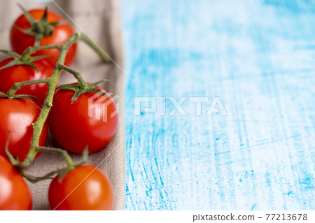 Cherry tomatoes on blue brushstroke background Cherry tomatoes on blue brushstroke background 77213678
