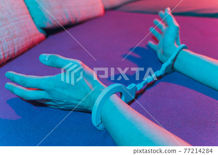 male and female hand in handcuffs. couple in bed. sex Toys. 77214284