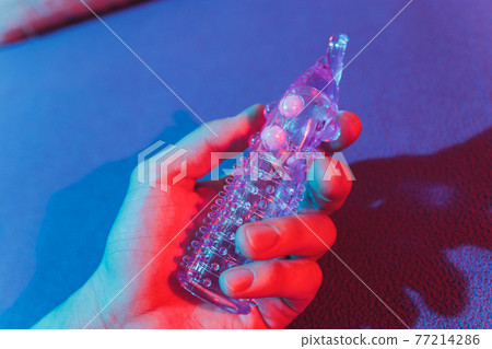 Sex toy - white penis sleeve on red background. 77214286