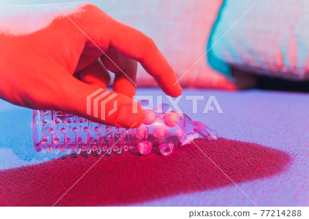 Sex toy - white penis sleeve on red background. 77214288