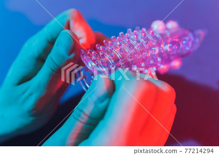 Sex toy - white penis sleeve on red background. 77214294