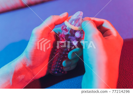 Sex toy - white penis sleeve on red background. 77214296