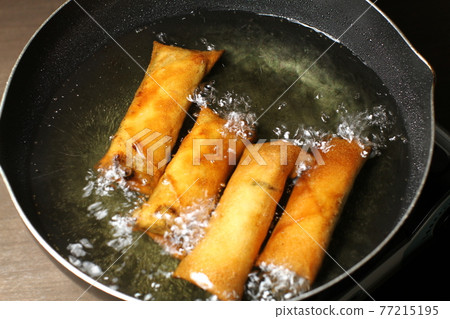 Spring roll cooking scene, fried in oil 77215195