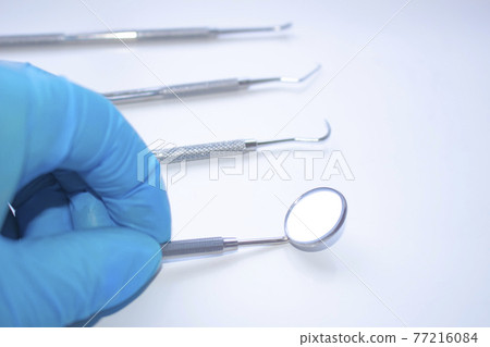 A dentist starts examining a patient. Professional Dental Hygiene cleaning tools. Calculus and Plaque Remover Set, Dental Scaler And Mouth Mirror Instruments Hygienist tools 77216084