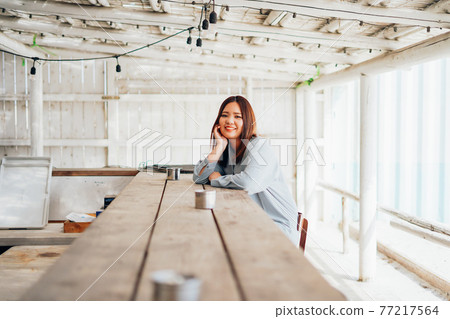 Woman sitting at bar counter Woman sitting at bar counter 77217564