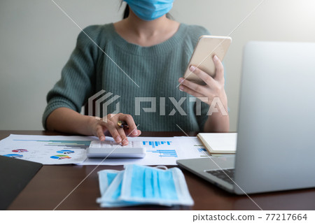Close up Business woman using calculator and laptop for do math finance on wooden desk in home office, tax, accounting, statistics and analytic research concept Close up Business woman using calculator and laptop for do math finance on wooden desk in home office, tax, accounting, statistics and analytic research concept 77217664
