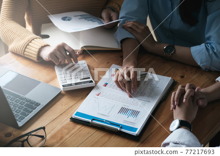 Young accountant marketing team consultants and using calculator to analyze sales growth in the global workplace market. accounting concept Young accountant marketing team consultants and using calculator to analyze sales growth in the global workplace market. accounting concept 77217693