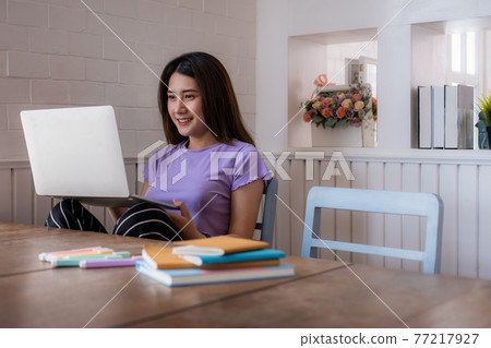 Young designer sitting on chair and chatting with her team by video call. Quarantine covid-19 concept. Young designer sitting on chair and chatting with her team by video call. Quarantine covid-19 concept. 77217927