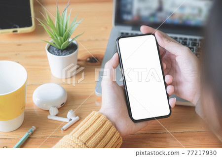 Asian woman holding smartphone with blank screen frameless modern design. Technology concept. Asian woman holding smartphone with blank screen frameless modern design. Technology concept. 77217930