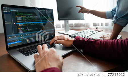 Team of Programmer working to find solution to problem and coding technologies in a software developing company office. Team of Programmer working to find solution to problem and coding technologies in a software developing company office. 77218012