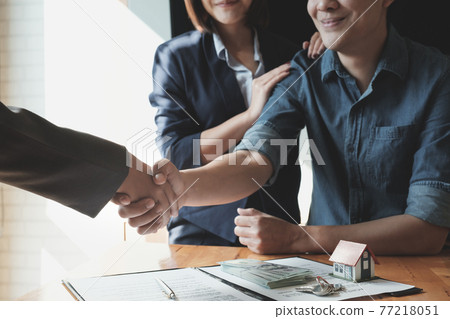 Young Asian Couple shaking hands with Estate agent after contract signature. Real Estate concept. 77218051
