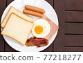 Simple breakfast. Toast bread, fried egg, sausage, ham and bacon. 77218277