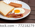 Simple breakfast. Toast bread, fried egg, sausage, ham and bacon. 77218279