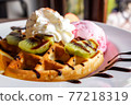 Homemade waffle served with stawberry ice cream and variety fruit. Sweet and crunchy dessert. 77218319